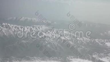 鸟瞰雪山云海.. 从飞机上看山上的褶皱。 山顶覆盖着